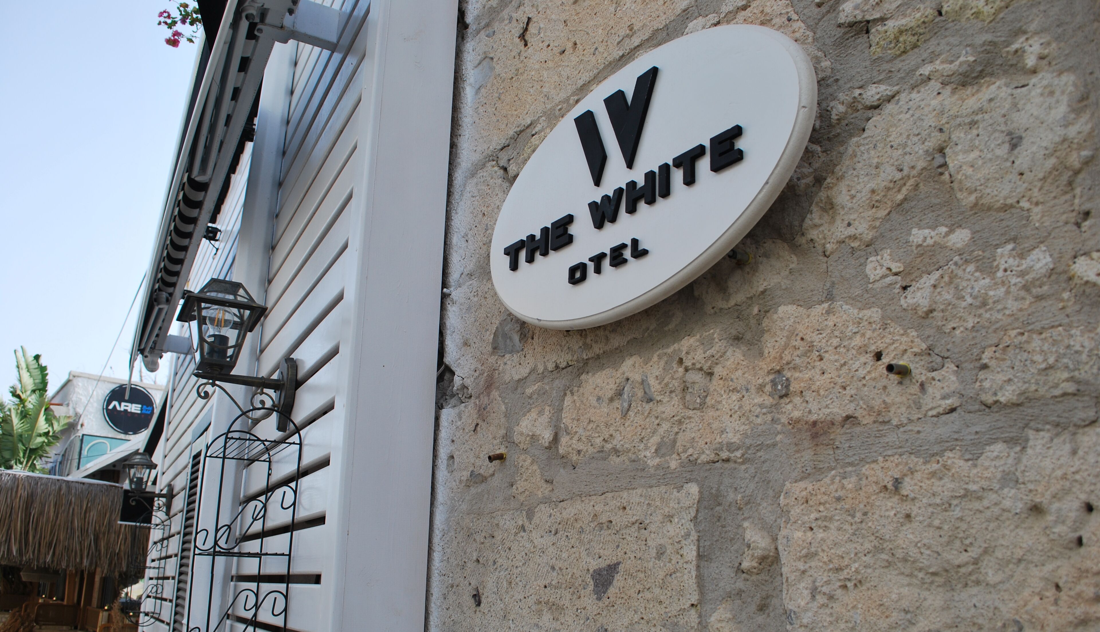 Un letrero que dice 'The White Hotel' sujeto a una pared de piedra.
