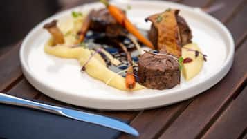 A plate of food with various items including meat, vegetables, and garnishes.