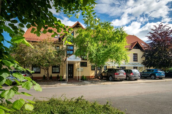 A hotel with a red-tiled roof, a sign reading "Zum Sternhof Hotel & Restaurant," and several parked cars along the street. - Hotel zum Steinhof (Bad Blankenburg)