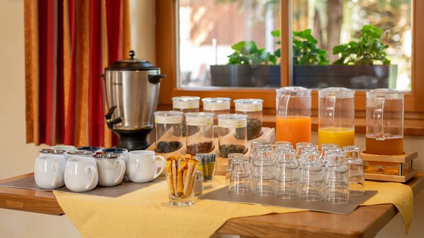 Montaje de un bufé de desayuno con cafeteras, dispensadores de té y jarras de jugo.
