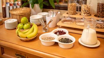 A buffet table with various food items including fruits, grains, and dairy products.