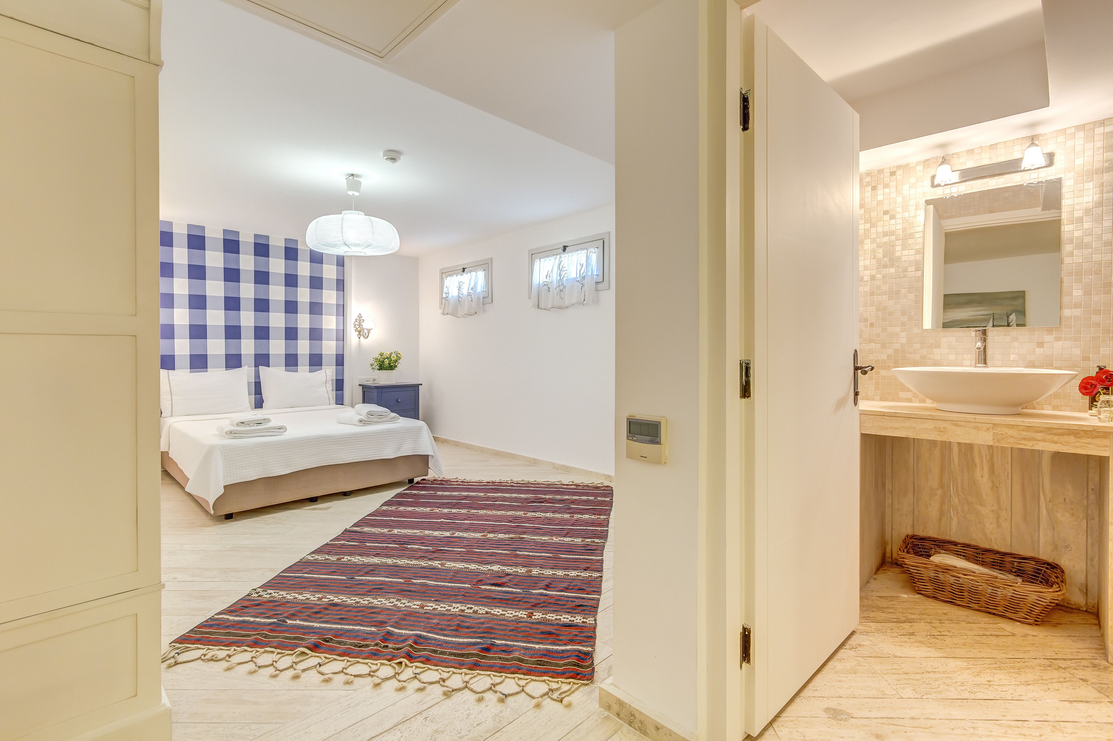 Une chambre à coucher moderne avec un mur à carreaux, un grand lit, une table de chevet et une commode.