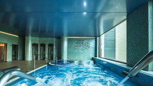 A hot tub with a tiled wall and a window. - Hotel Mas Solà (Santa Coloma de Farners)