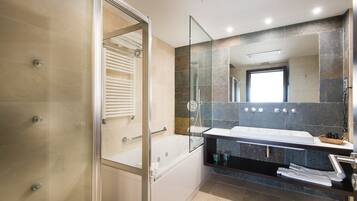 Une salle de bain moderne avec une douche à parois de verre, une grande baignoire et un meuble-lavabo avec un miroir.