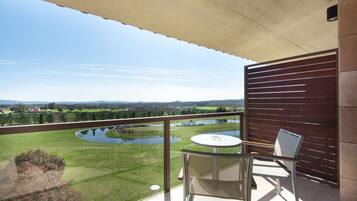 Un balcon donnant sur un lac, une petite table et deux chaises.