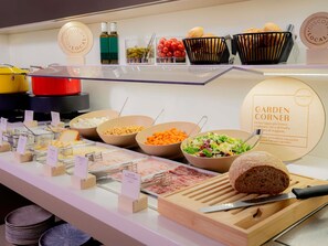 Un espace buffet proposant une variété de plats, notamment des viandes, des fromages et des salades.