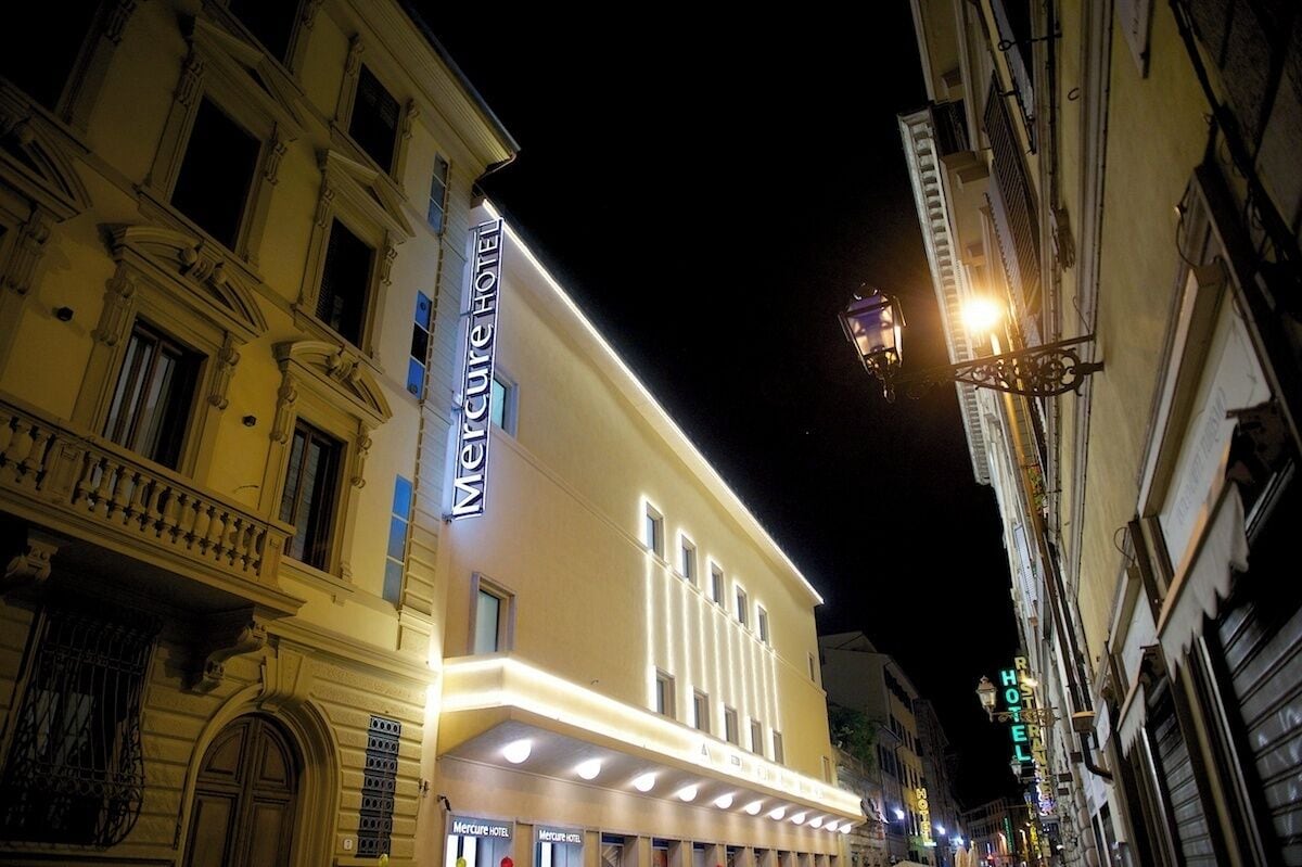 Un hôtel à la façade classique, doté de grandes fenêtres et d’une enseigne bien visible.