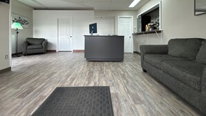 Un salon moderne avec un canapé gris, un meuble de rangement gris foncé et un téléviseur à écran plat.