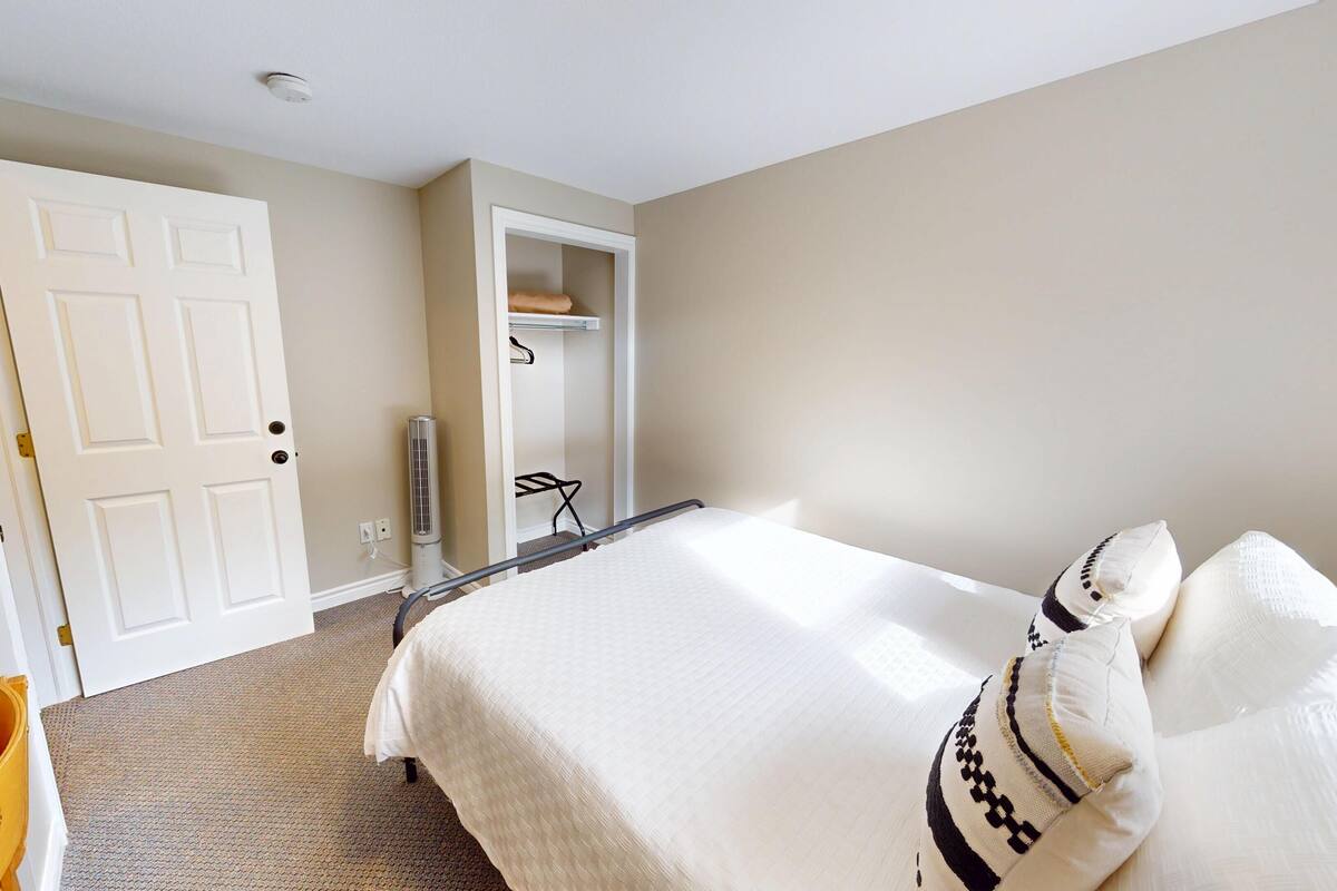 A bedroom with a bed, a wardrobe, and a heater.