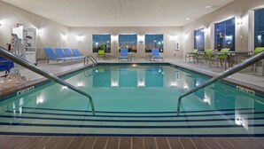 Una piscina con sillas azules y un punto de recogida de toallas.