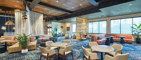A spacious lobby with a patterned carpet, wooden ceiling, and seating areas including sofas and tables.