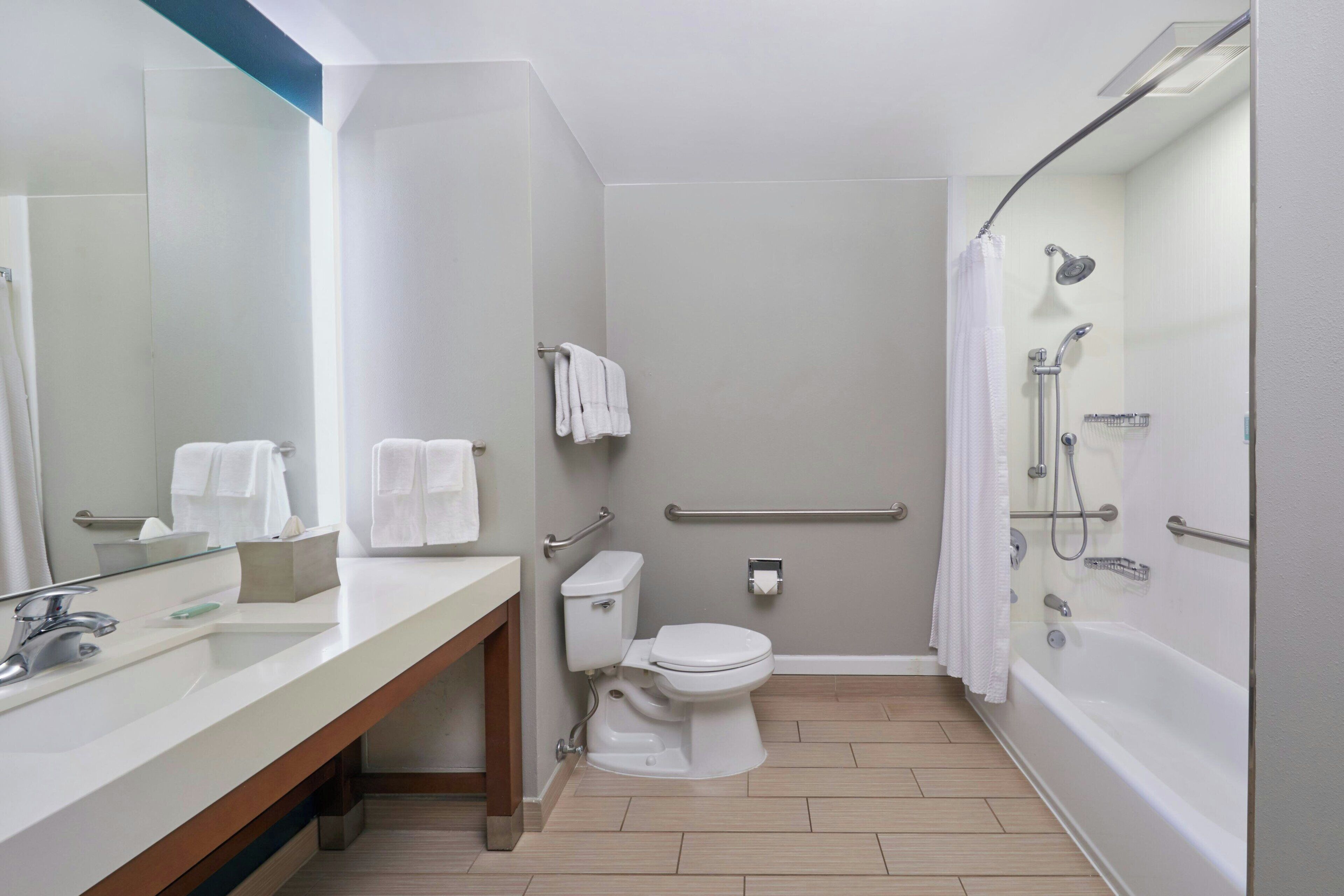 A modern bathroom with a sink, toilet, and bathtub.