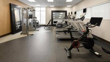 A gym with cardio machines, weightlifting equipment, and mirrors.