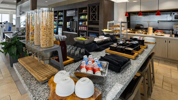 A buffet setup with various food items and condiments. - Hilton Garden Inn Memphis/Wolfchase Galleria (Cordova)