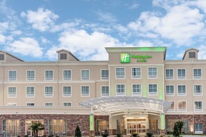 Un hotel Holiday Inn & Suites con entrada cubierta y fachada de ladrillo.
