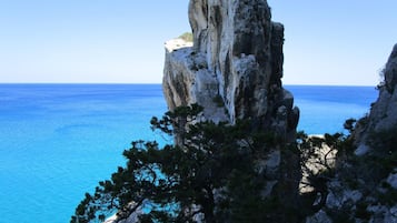 A rocky cliff with a clear view of the ocean.