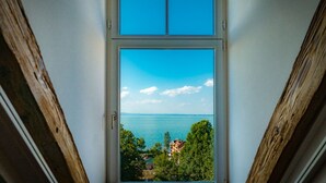 Vista a través de una ventana con cielo despejado y un paisaje lejano.