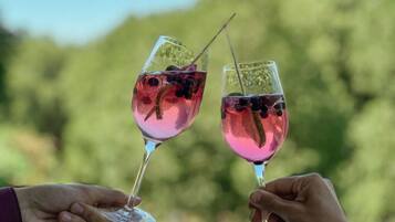 Two people holding wine glasses with a blurred green background.