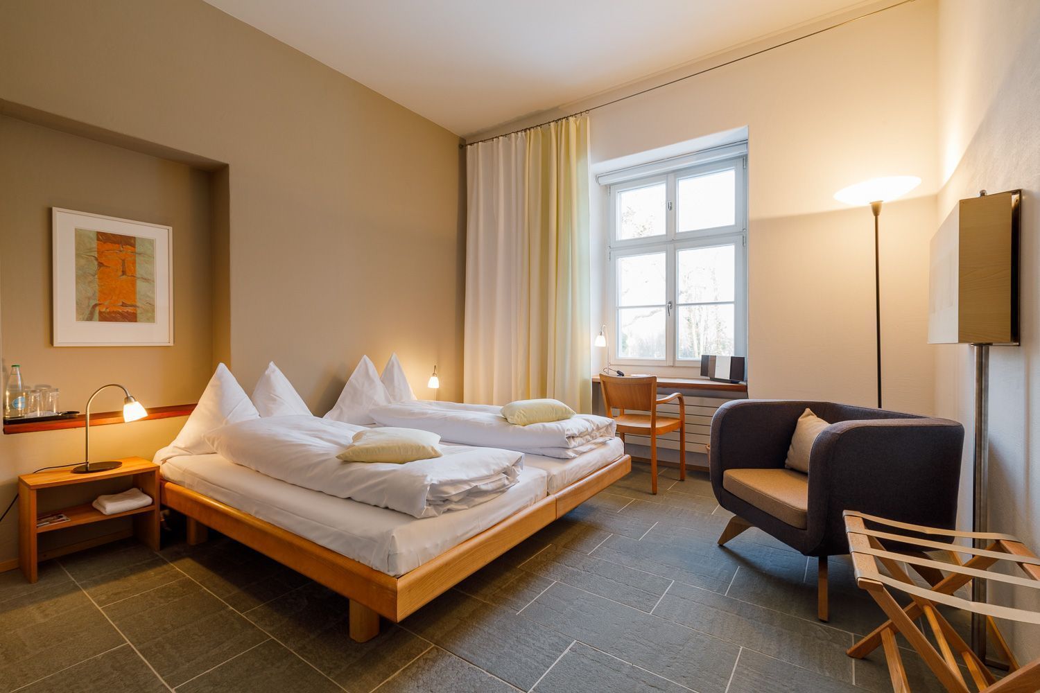 Ein Hotelzimmer mit Bett, Schreibtisch, Stuhl und Fernseher.