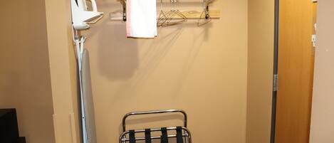 A bathroom with a towel rack, a drying rack, and a mirror.