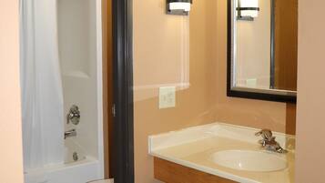 A bathroom with a toilet, sink, and shower.