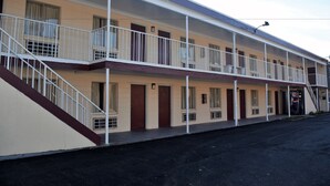A motel with two-story balconies, a central staircase, and a flat roof. - Fort Eustis Inn (Newport News)