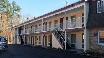 A motel with a two-story structure, a central staircase, and a parking lot.