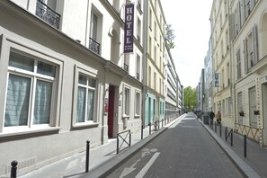 A street with buildings on either side, including a hotel with a sign. - Hotel du Quai de Seine (Paris)