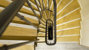 Una escalera de caracol con escalones de madera y barandillas de metal.