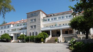 A historic building with a stone tower, multiple floors, and a covered entrance. - Hotel Urgeiriça (Nelas)