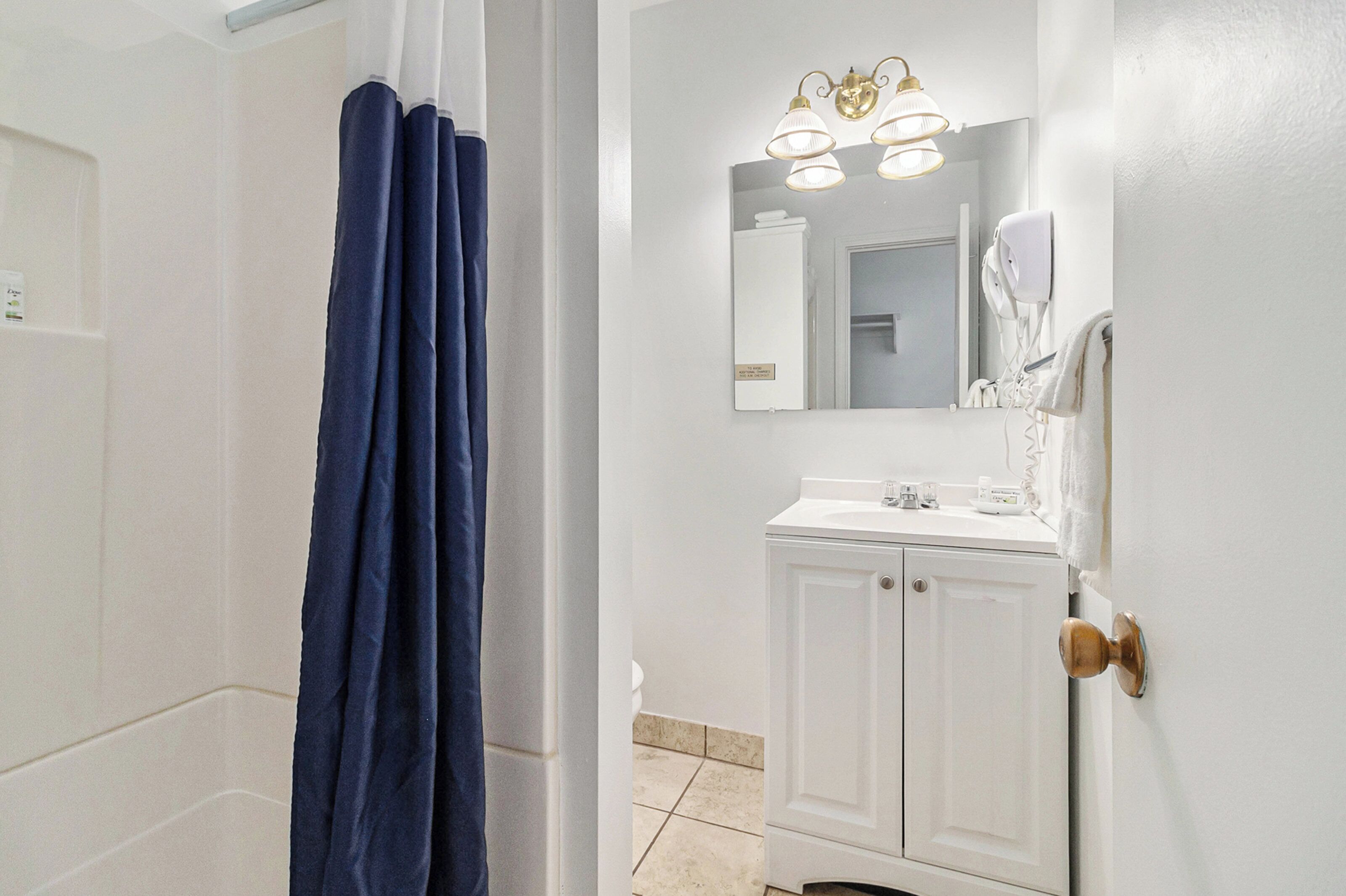 A bathroom with a white sink, mirror, and towel rack.