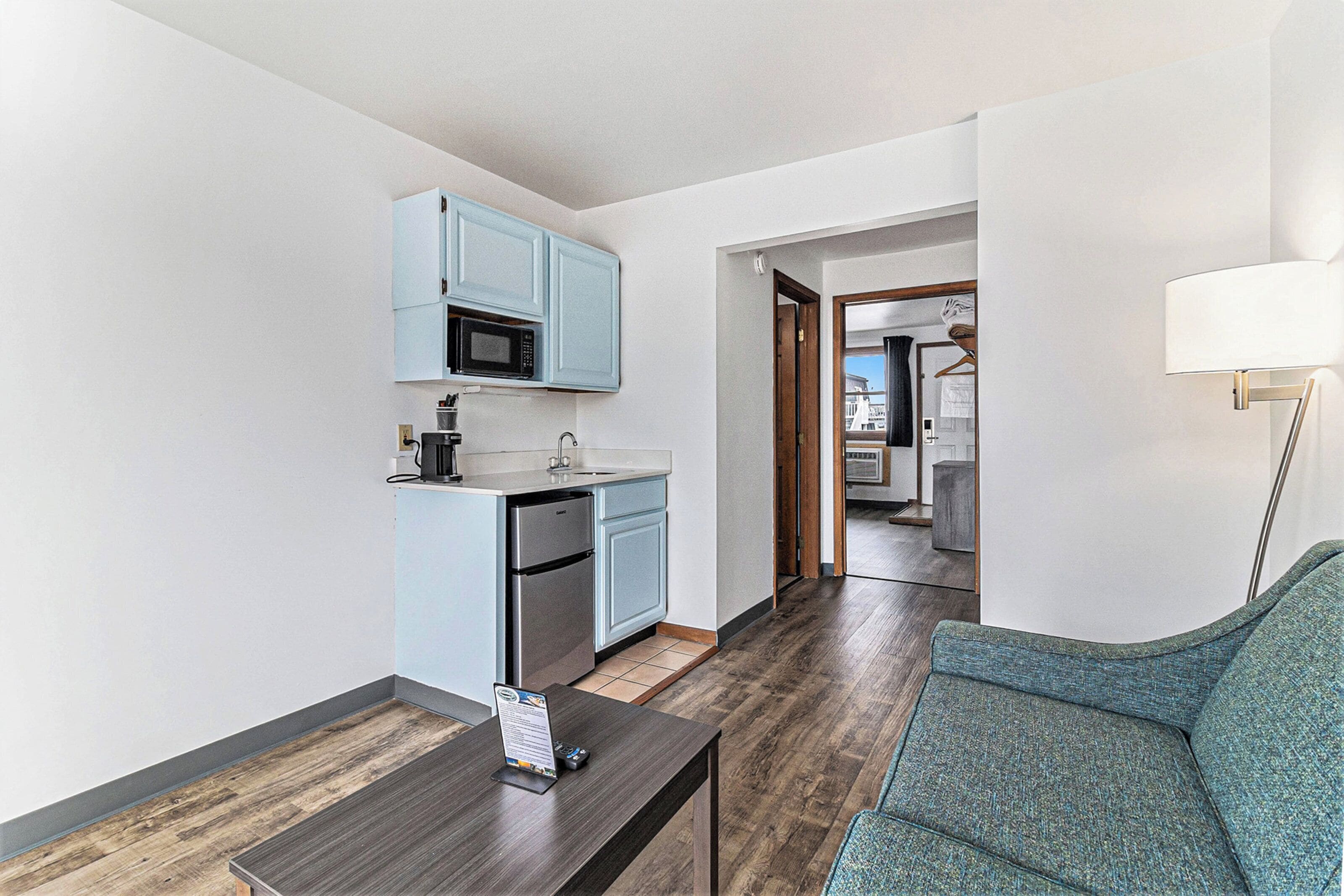 A compact living space with a kitchenette, a dining area with a table, and a sofa.