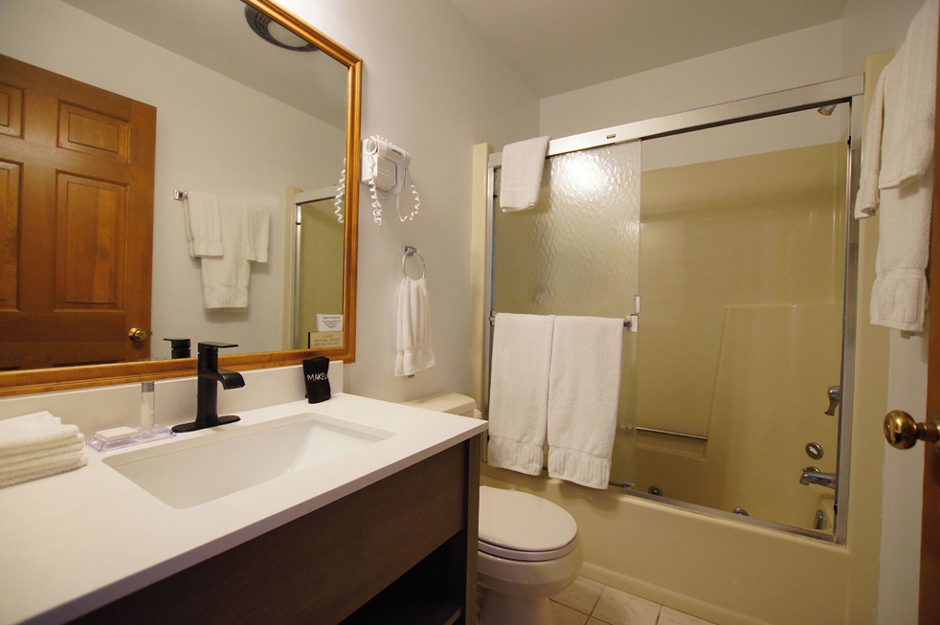 A bathroom with a sink, toilet, and a glass-enclosed shower.