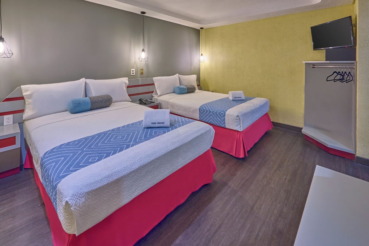 Hotellihuone, jossa on kaksi sänkyä, televisio ja vaatekaappi.