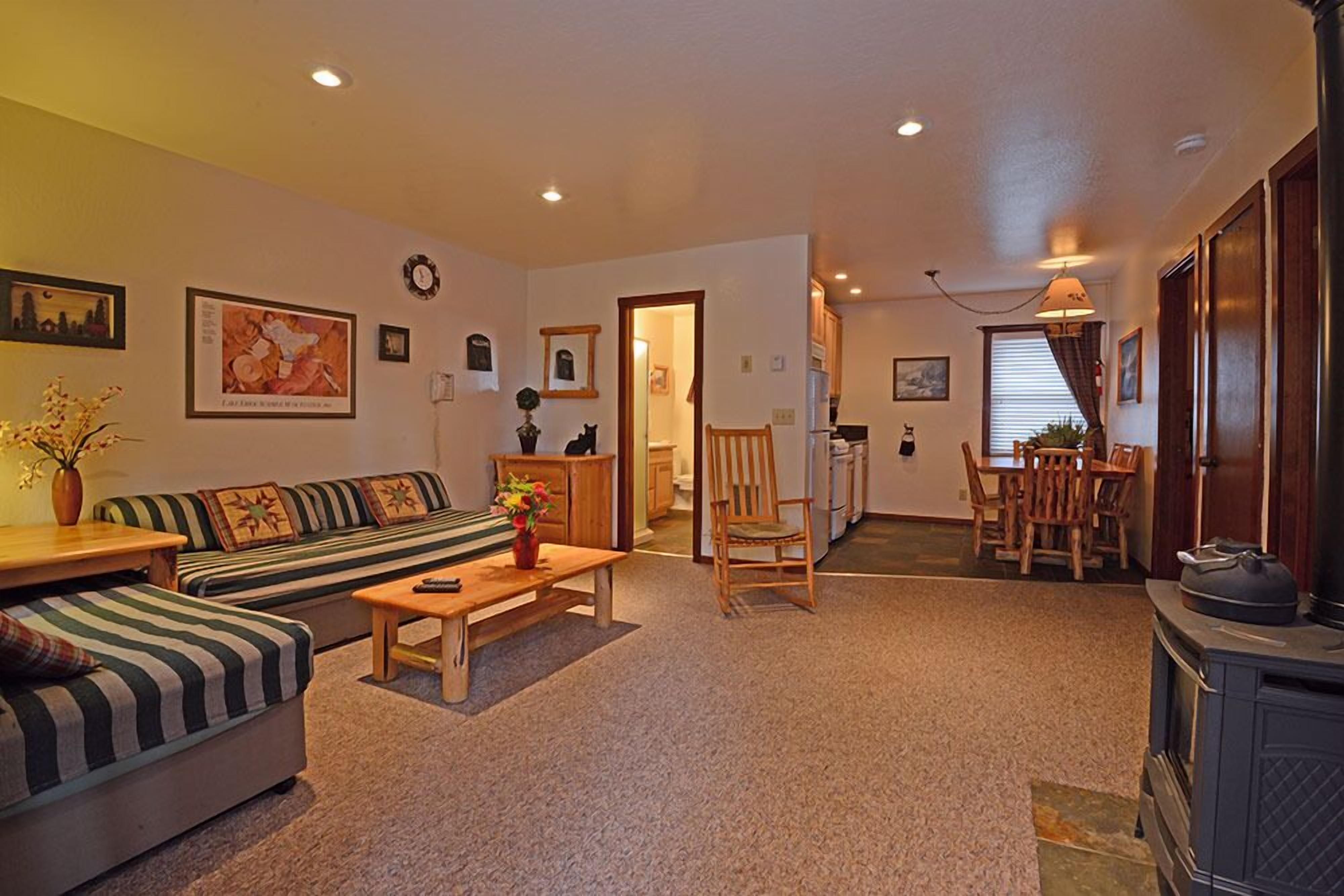 A cozy living room with a sofa, a chair, a table, and a fireplace.
