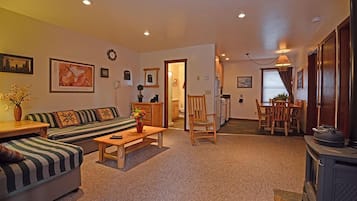 Una sala acogedora con un sofá, una silla, una mesa y una chimenea.