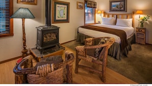 Un dormitorio acogedor con cama, una silla de madera, una lámpara, un mapa y una chimenea.