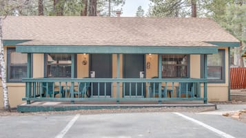 A small, single-story building with a porch, numbered rooms, and a parking area.