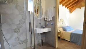 Une salle de bain avec une douche à parois de verre, un lavabo et un miroir.