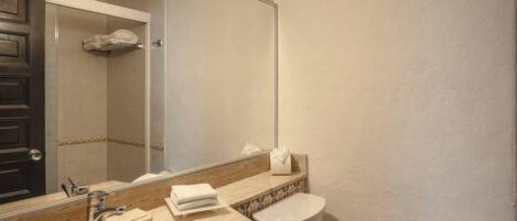 A bathroom with a sink, mirror, toilet, and towel rack.