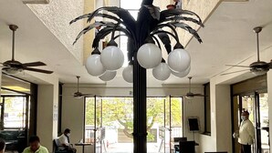 A dining area with a central black sculpture, multiple ceiling fans, and large windows allowing natural light. - Hotel del Paseo Campeche (Campeche)