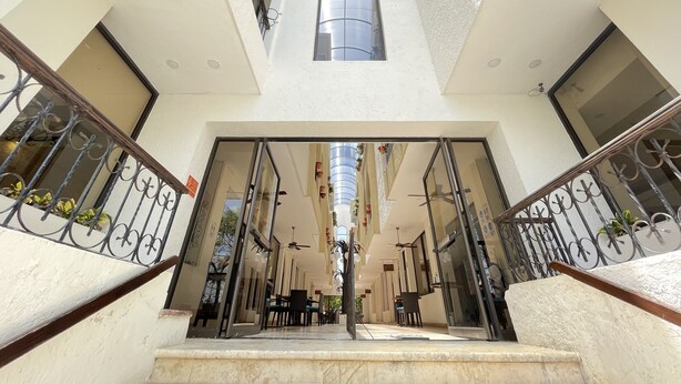 A multi-level building with a central staircase, glass doors, and a ceiling fan. - Hotel del Paseo Campeche (Campeche)