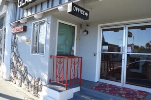 A building with a sign reading "GLASS OFFICE" and a red metal railing in front of the entrance.
