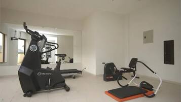 A home gym with an elliptical, a treadmill, and a stationary bike.
