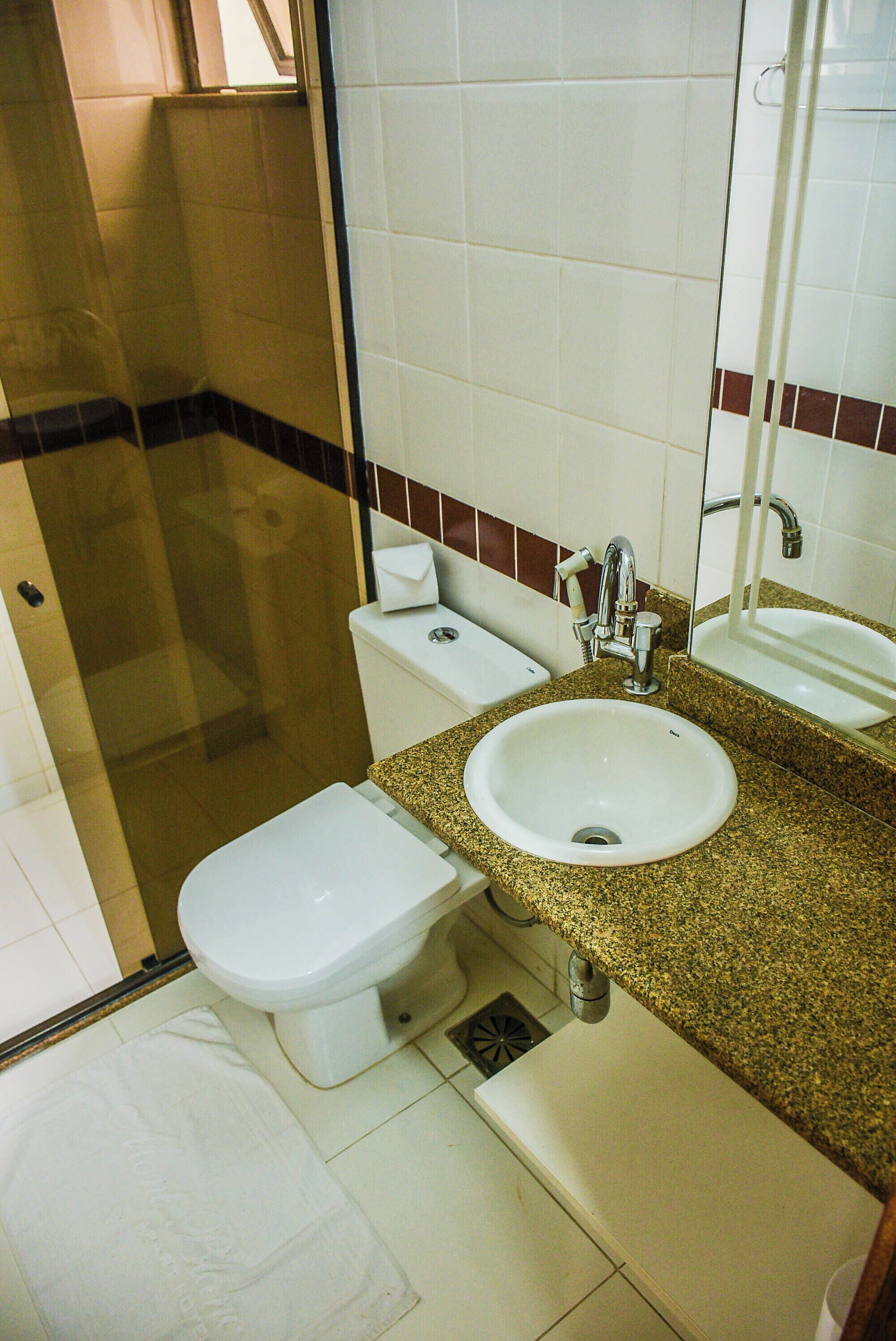 Un baño con inodoro, lavamanos y ducha.
