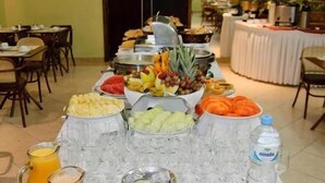 A buffet table with various fruits, juices, and water bottles. - Mont Blanc Nova Iguaçu (Nova Iguaçu)