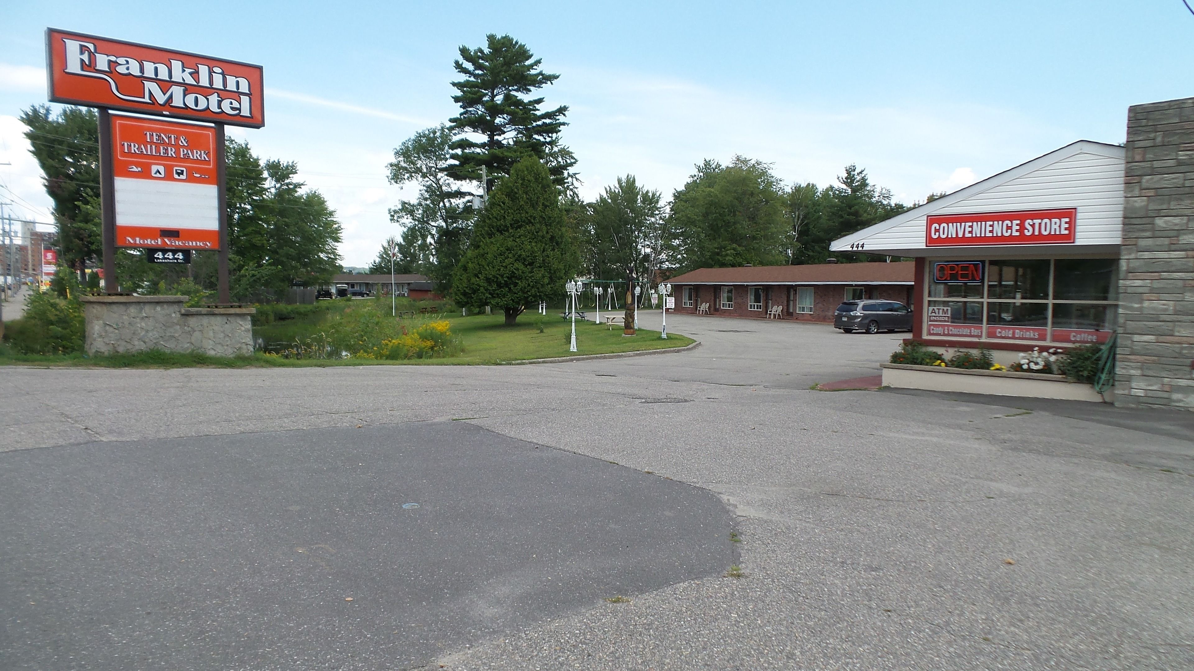 Un motel appelé Franklin Motel, avec un panneau indiquant la présence d’emplacements pour tentes et de caravanes, une épicerie et un parking.