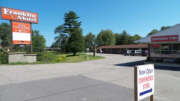 A motel with a tent and trailer park sign, a convenience store, and a parking area.