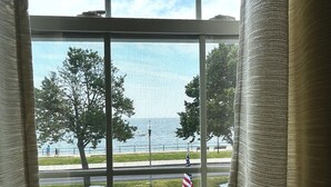 A window with a view of a street, a flag, and flowers. - Harborview Inn (Gloucester)