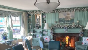 A dining area with a table set for six, surrounded by blue upholstered chairs. - Harborview Inn (Gloucester)